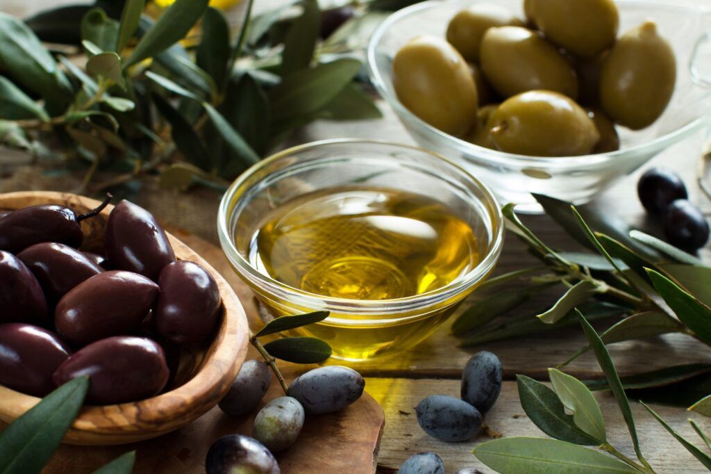Olive oil and olives on wood background